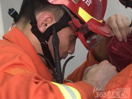 消防队员高温下耐心救援。