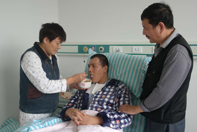 盛学林照顾从植物人状态中醒来的儿子