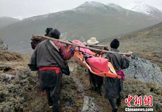 藏族同胞抬着获救的伤者下山。　叶强平 摄