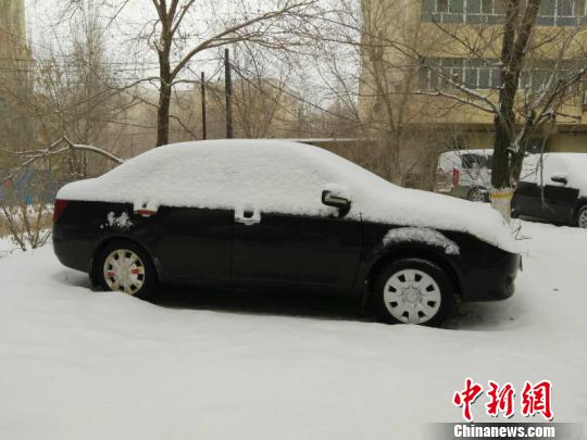 小汽车被积雪覆盖，大地银装素裹。　戚亚平 摄