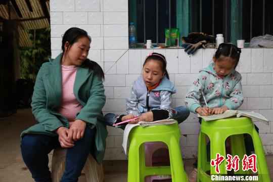 放学回家，游成雪用脚写作业。　陈本强 摄