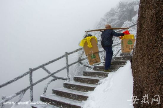 方银善雪后挑货物上山。