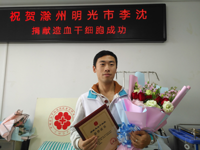 李沈捐献干细胞成功后手持荣誉证书和鲜花留影