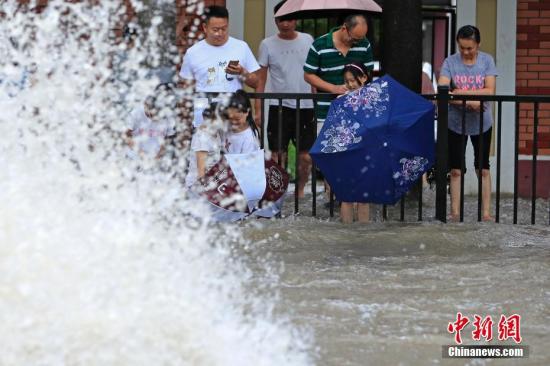 8月10日，上海北华路出现严重积水，市民路边看&ldquo;海&rdquo;。上海中心气象台于当日14时20分更新暴雨黄色预警信号为暴雨橙色预警信号。受台风&ldquo;利奇马&rdquo;影响，预计未来6小时内中心城区、嘉定、闵行、奉贤、浦东等地最大小时雨强可达60-80毫米。<a target='_blank' href='http://www.chinanews.com/'>中新社</a>记者 殷立勤 摄
