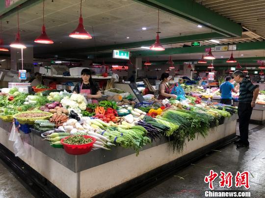 玉环市区的一菜市场内,人流不断。菜贩蔡飞苹正整理着当天刚送达的新鲜蔬菜。 潘沁文 摄 玉环市区的一菜市场内,人流不断。菜贩蔡飞苹正整理着当天刚送达的新鲜蔬菜。 潘沁文 摄