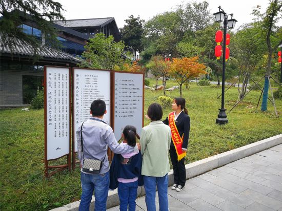 2019年10月6日上午，琅琊山风景区文明旅游志愿者在北大门游客服务中心广场向游客一家介绍《文明旅游十大提醒语》《滁州市民公约》等标牌内容，倡导文明旅游