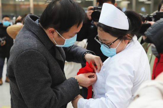 出征仪式前，爱人为她戴上红花