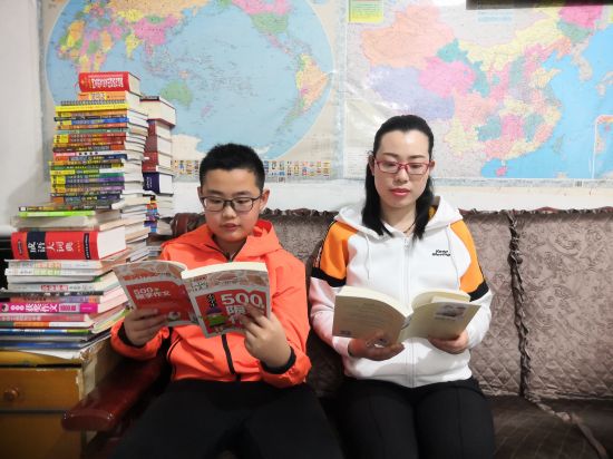 邰春李和儿子李悠一起阅读书籍