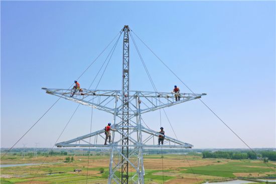 电力工人在60多米高空对B37号塔进行组塔作业。 宋卫星、陈焱供图