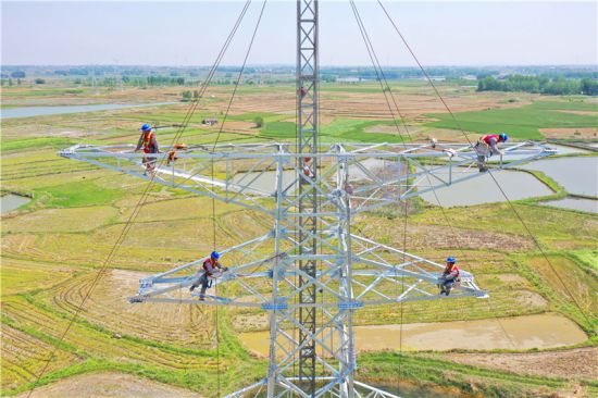 电力工人在60多米高空对B37号塔进行组塔作业。 宋卫星、陈焱供图