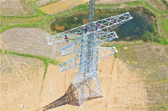 电力工人在60多米高空对B37号塔进行组塔作业。 宋卫星、陈焱供图