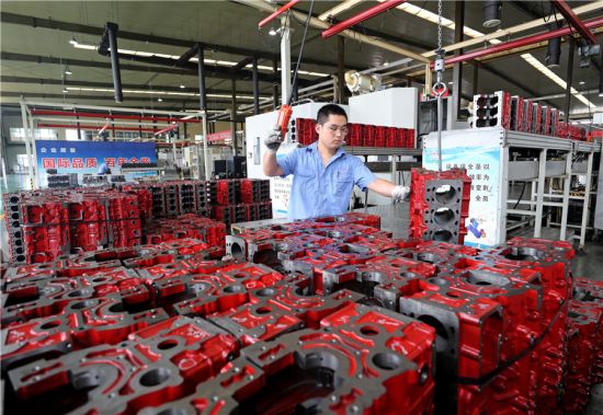 9月7日，在安徽全椒经济开发区，工人在一家装备制造企业搬运柴油机缸体。沈果摄