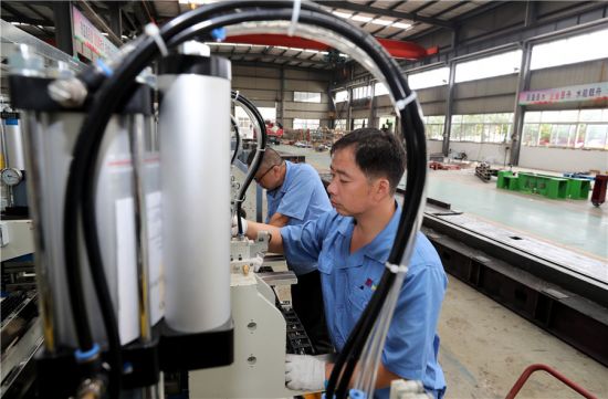 9月7日，在安徽全椒经济开发区，工人在一家装备制造企业加工制作冷柜生产线。 沈果摄