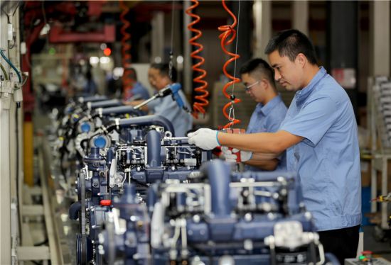9月8日，在安徽全椒经济开发区，工人在一家装备制造企业装配工程机械柴油机。 沈果摄