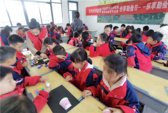 市博物馆志愿者指导学生制作手工品