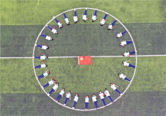 学生手持小红旗和党旗合影