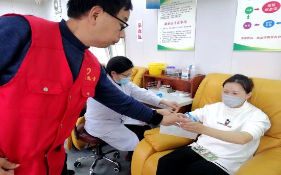 杨万平（左一）在献血屋为献血者倒水