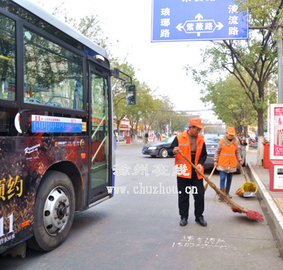 姜汉翠和吴从友正在清扫马路。