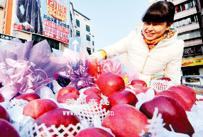 一名女士在街头挑选“平安果”。