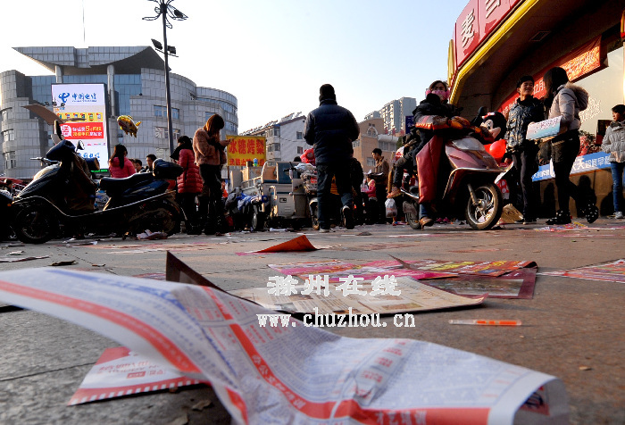 图为街面上撒落一地的广告单。