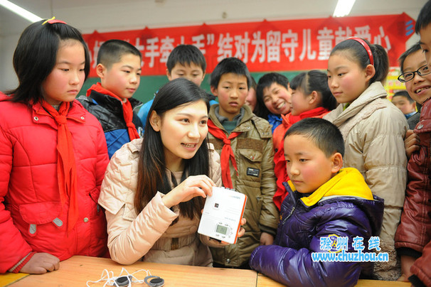 爱心妈妈在为“留守儿童”讲解语音复读机使用方法